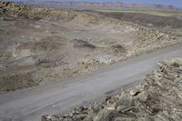 the truck is driving down the road in the desert terrain area of this area of mountains