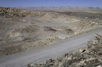 the truck is driving down the road in the desert terrain area of this area of mountains