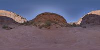 two rocks and grass in a small desert valley with the same area where the two rock are