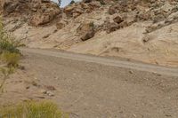 a motorcycle is going down a dirt road in the mountains in the desert in arizona