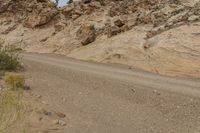 a motorcycle is going down a dirt road in the mountains in the desert in arizona