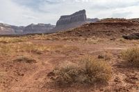 a couple of rocks that are in the desert in front of some mountains - -