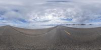 two rows of empty road with cloudy sky in the background and one on the left of the road looking straight