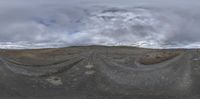 a spherical fish eye lens view of the desert landscape and clouds above it, with vegetation growing out of the mountains