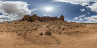 a desert scene in a wide angle view with a sky in the background and sun rising