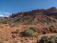 the view of a dry, arid desert and a blue sky above it is a mountain