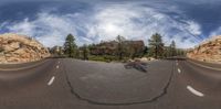 a fish - eye lens lens, looking across an empty road that is surrounded by rocky terrain