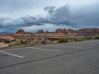 a parking lot with no one in it, and dark clouds above the scene on top