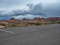 a parking lot with no one in it, and dark clouds above the scene on top