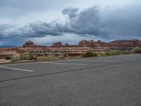 a parking lot with no one in it, and dark clouds above the scene on top