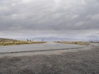 there is an empty road going into a rural area on a cloudy day with the sun