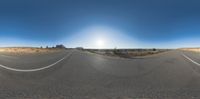 an empty road that has two straight white lines on the road and a clear sky in the background