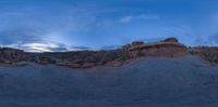 there is a view of the rocks and a cloudy sky at sunset as seen through a fish eye lens