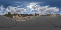 a fisheye lens captures a desert setting and street scene from the outside looking out