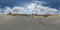 a fisheye lens captures a desert setting and street scene from the outside looking out