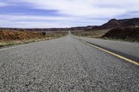 an empty roadway stretches through the hills of arid deserts in california's southwest hills