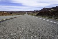 an empty roadway stretches through the hills of arid deserts in california's southwest hills