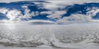 snow is melting in front of a large amount of clouds on a blue sky background