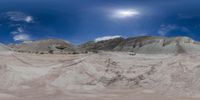 two mountains with snow and clouds in the sky and a sun setting above them, seen from a fish - eye view