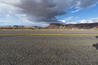 an asphalt road in the middle of an arid, mountain - range area in arizona