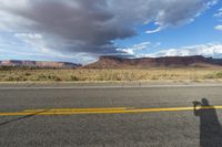 an asphalt road in the middle of an arid, mountain - range area in arizona