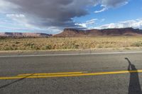 an asphalt road in the middle of an arid, mountain - range area in arizona