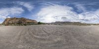 a panorama style image of a road running through a landscape with mountains and trees in the background