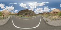 a 360 - shot of a highway in the mountains below some trees and a rock formation