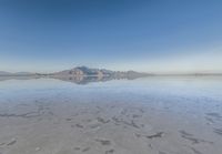 a view from the water of a sandy beach in arizona's death valley to mountains