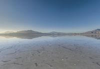 a view from the water of a sandy beach in arizona's death valley to mountains