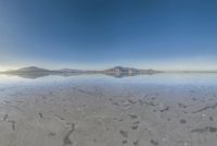 a view from the water of a sandy beach in arizona's death valley to mountains