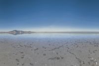 a view from the water of a sandy beach in arizona's death valley to mountains