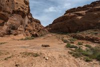 desert terrain with dirt and grass in the middle and one stone in the corner, looking into the distance