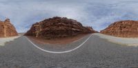 a mountain pass is featured in this distorted photo with a person on a motorcycle and several mountains below it