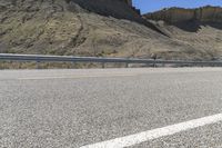 a black and white motorcycle is parked along a mountain road next to a curve road