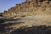 a large canyon covered in rocks and sand near the water's edge during the day