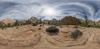 a panoramic view of a cliff and clouds in the sky with the sun shining down