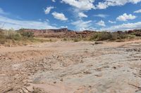 a rocky field with large rocks and mountains behind it in the distance is an arid area