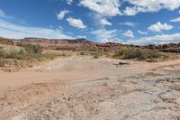 a rocky field with large rocks and mountains behind it in the distance is an arid area