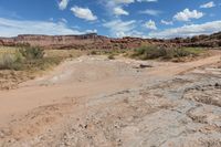 a rocky field with large rocks and mountains behind it in the distance is an arid area