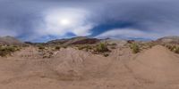 a large desert with some dirt and dirt piles on the ground and one person in the distance