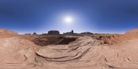 a 360 view of the landscape with mountains and rocks, some rocks are in the background and another is a desert area