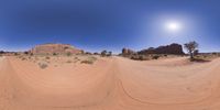 a 360 view of the landscape with mountains and rocks, some rocks are in the background and another is a desert area