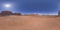 a 360 view of the landscape with mountains and rocks, some rocks are in the background and another is a desert area