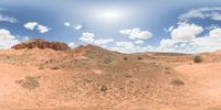 a 360 view of the landscape with mountains and rocks, some rocks are in the background and another is a desert area