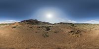 a wide view shows the terrain of the desert on a sunny day with low clouds