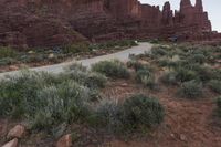 a road passing through a canyon on top of the mountain side with cars parked nearby