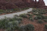 a road passing through a canyon on top of the mountain side with cars parked nearby