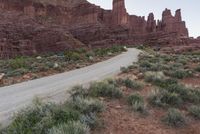 a road passing through a canyon on top of the mountain side with cars parked nearby