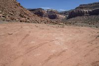 a dirt road in a canyon with lots of rocks on each side and grass in the middle